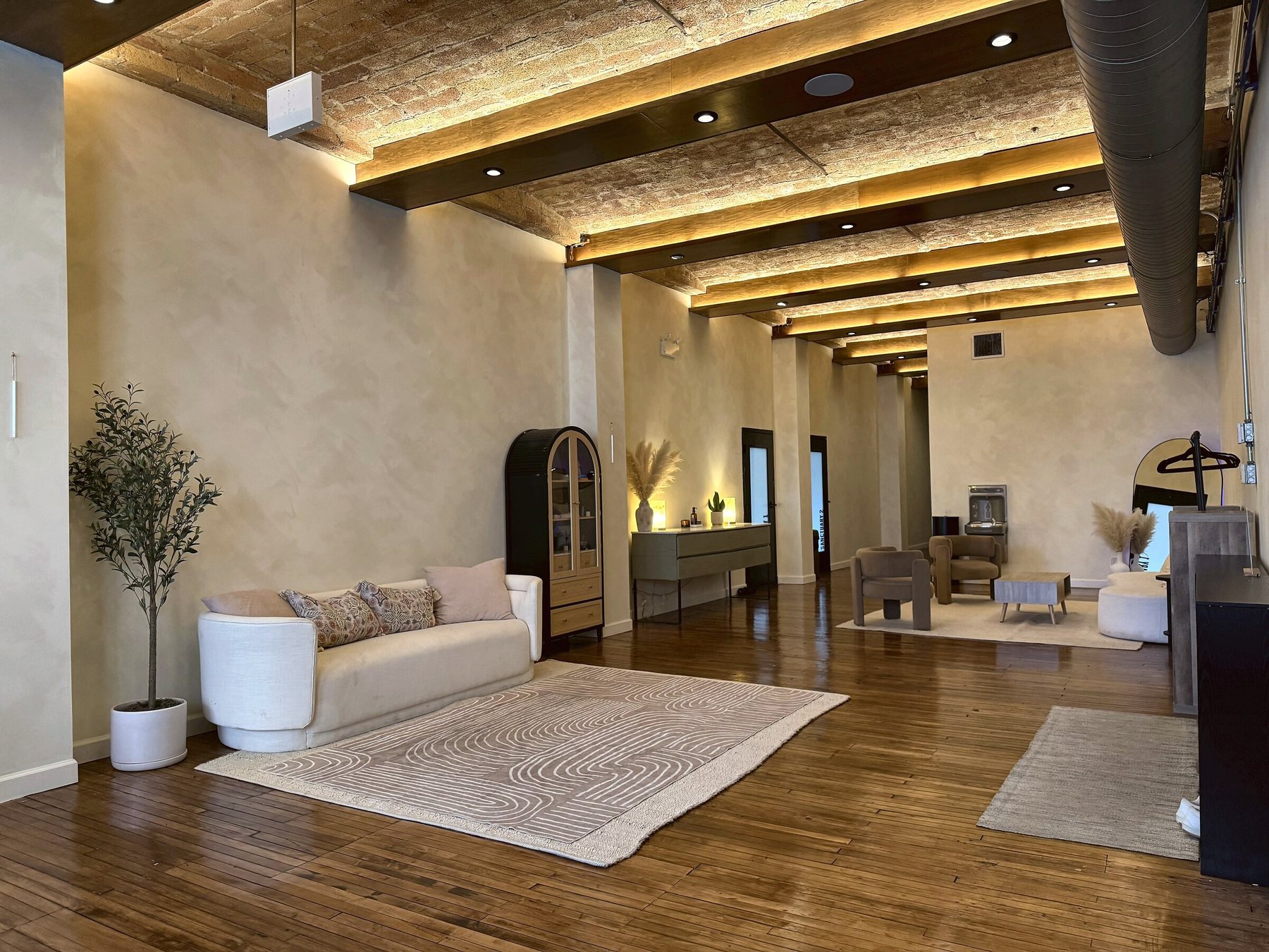 The Yoga 2.0 lounge in River North, Chicago, with exposed brick ceilings, hardwood floors, and warm lighting